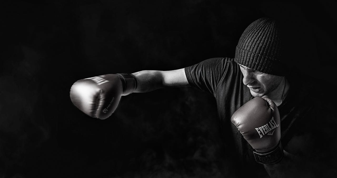 A powerful black and white image of a boxer throwing a punch, showcasing strength and focus.